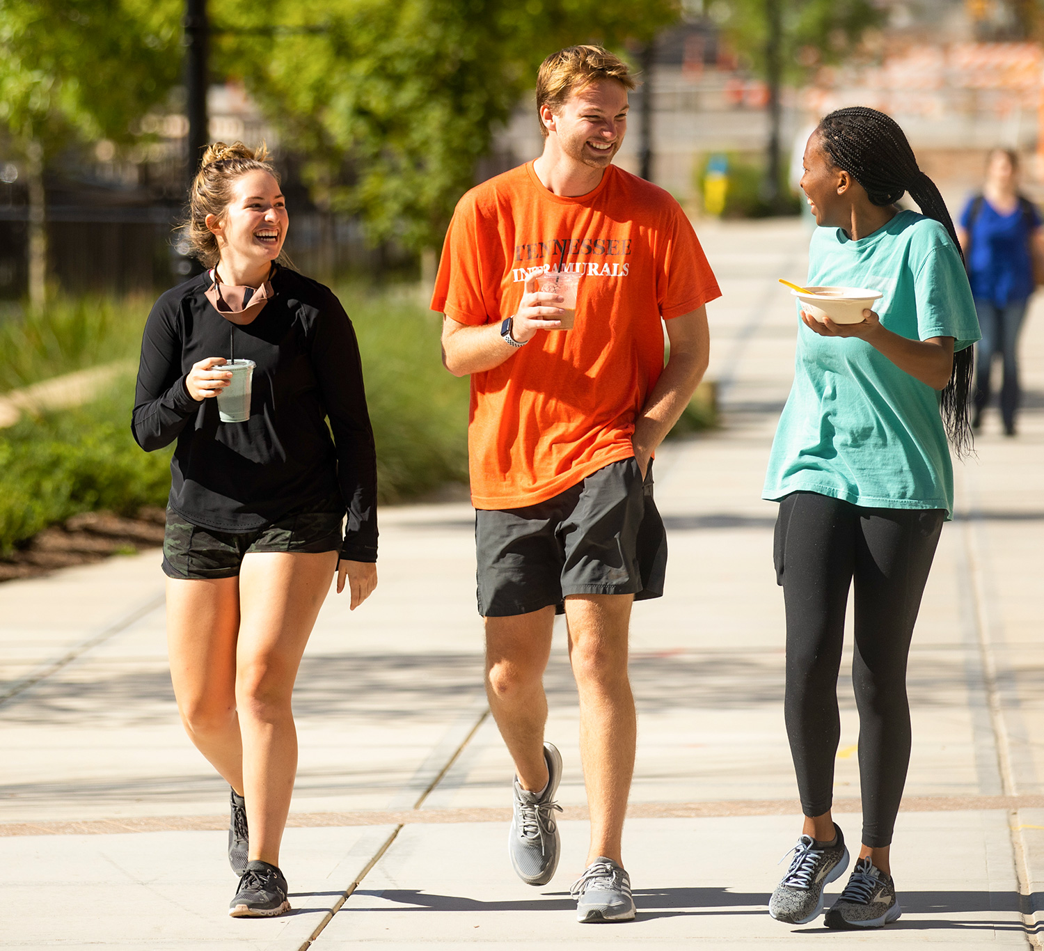 several smiling students walk together through campus
